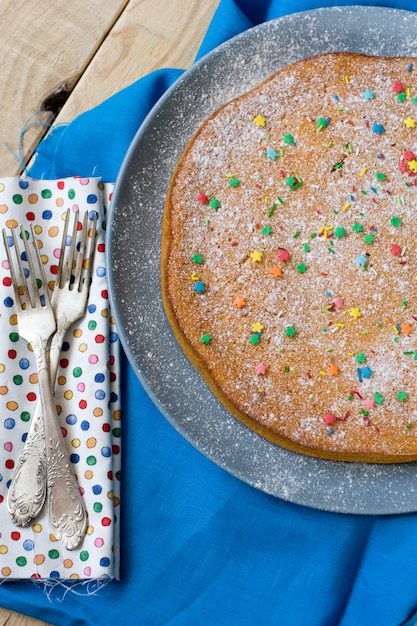 Foto un delicioso pastel de zanahoria en un plato sobre gris. se alza sobre una mesa de madera sin pintar.