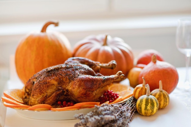 Delicioso pavo de Acción de Gracias dorado asado en la mesa con calabazas