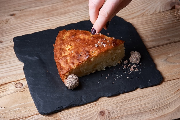 Delicioso pedaço cozido fresco de torta de maçã na placa de xisto, a mão ferve o chocolate