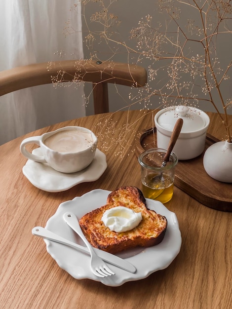 Delicioso pequeno-almoço sobremesa lanche café e brioche assado torrada francesa com iogurte grego e mel em uma mesa de madeira