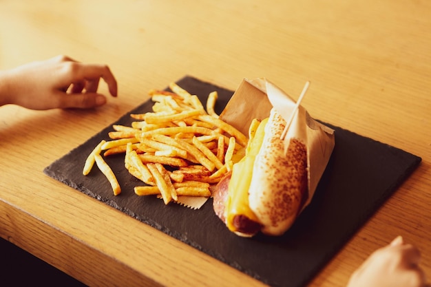 Delicioso perrito caliente casero en la mesa con papas fritas