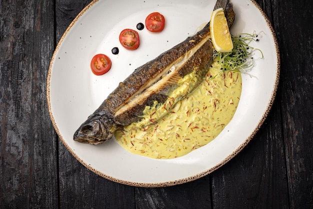 delicioso pescado a la parrilla con una guarnición. sobre un fondo oscuro