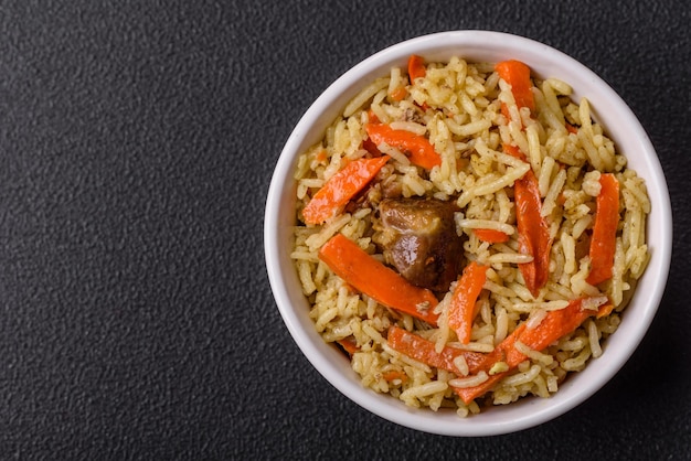 Delicioso pilaf con verduras, sal, especias y hierbas en un plato de cerámica