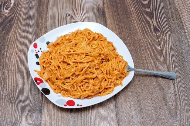 Delicioso plato de espaguetis en mesa de madera