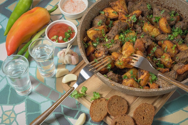 Delicioso plato georgiano ojaxuri con ternera frita y patatas al horno decorando con cebolla y eneldo de cilantro verde fresco