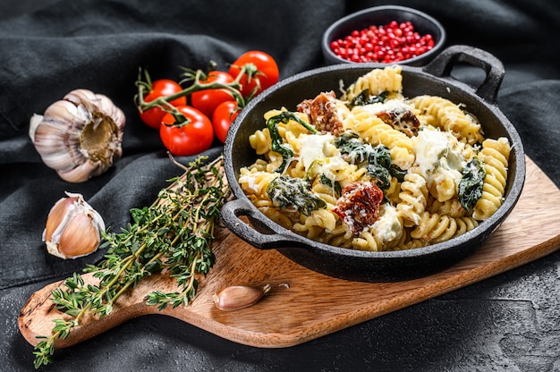 Delicioso plato de pasta fusilli con cremosa salsa de espinacas y tomates secos