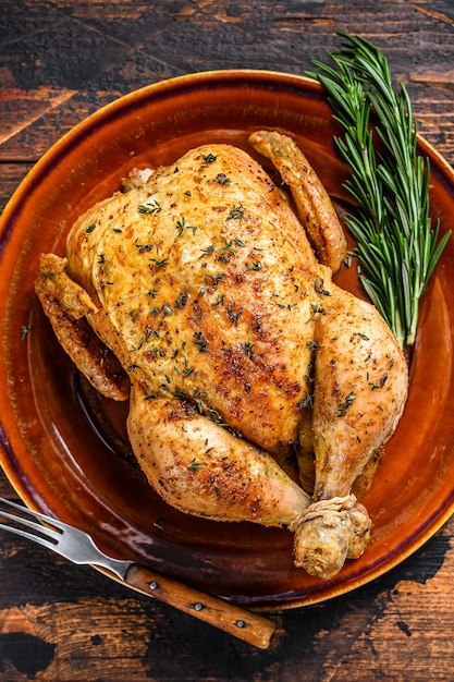 Delicioso pollo al horno en mesa de madera.