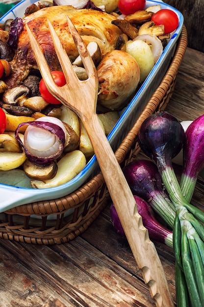 Foto delicioso pollo al horno con patatas y verduras frescas.