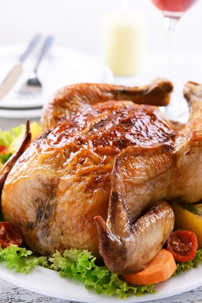 Foto delicioso pollo al horno en un plato sobre la mesa sobre una superficie clara
