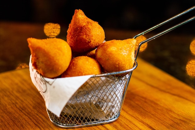 Delicioso pollo frito brasileño Coxinha Basket en una barra de bar