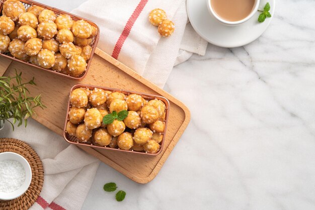 Delicioso postre francés Chouquette Choux Pastry Pearl Sugar Puff sobre fondo de mármol blanco