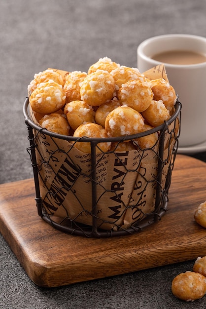 Delicioso postre francés Chouquette Choux Pastry Pearl Sugar Puff sobre fondo de mesa gris