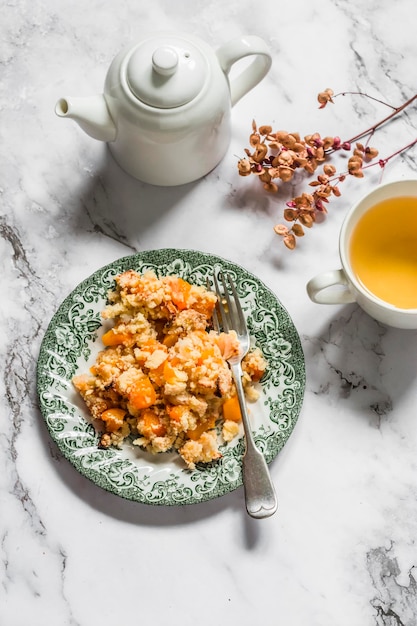 Delicioso postre de otoño calabaza desmenuzada y té verde en una vista superior de fondo de mármol