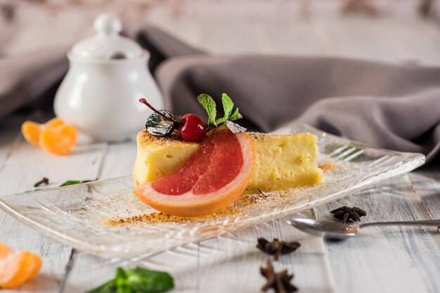 Delicioso postre tarta de queso con frutas sobre fondo de madera