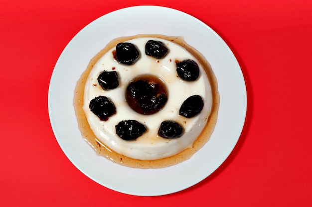 Delicioso postre tradicional brasileño conocido como Manjar de Coco Branco con salsa de ciruela