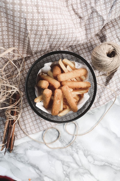 Delicioso prato de lanche batatas fritas anéis de cebola rolinhos primavera ou salsichas na mesa