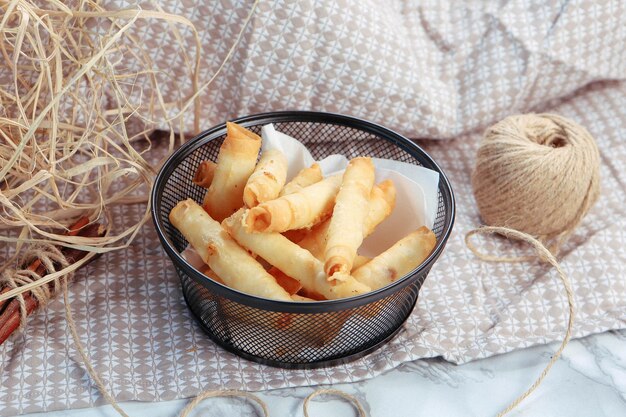 Delicioso prato de lanche batatas fritas anéis de cebola rolinhos primavera ou salsichas na mesa