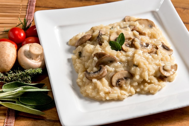 Delicioso prato de risoto de cogumelos em fundo de madeira