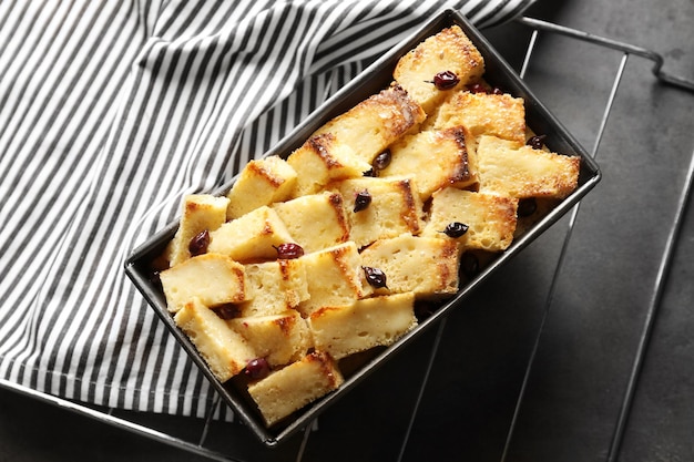 Delicioso pudim de pão com groselha na assadeira na mesa da cozinha