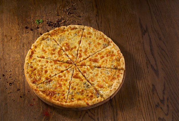 Delicioso Quadmagro formaggi, pizza de quatro queijos, vista superior na mesa de madeira