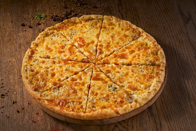 Delicioso Quadmagro formaggi, pizza de quatro queijos, vista superior na mesa de madeira