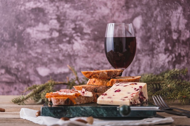 Delicioso queijo Cheddar britânico com cranberry em uma mesa de corte de queijo em mármore