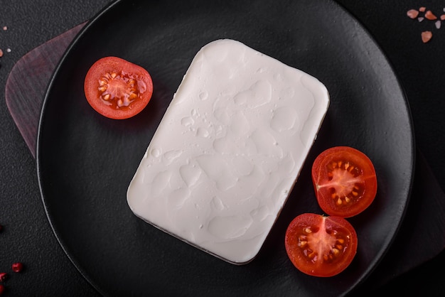 Delicioso queso feta fresco de forma rectangular con especias y verduras