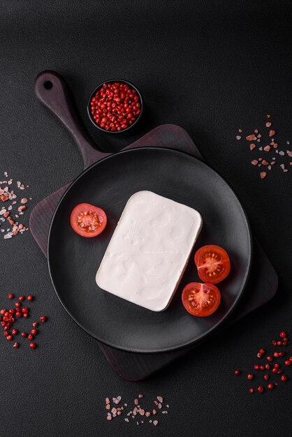 Delicioso queso feta fresco de forma rectangular con especias y verduras