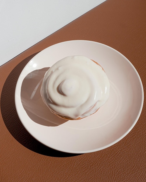 Delicioso rollo esmaltado con canela perfecto para un delicioso café concepto de panadería minimalista suave