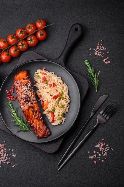 Delicioso salmón rojo a la plancha con salsa y semillas de sésamo con arroz y verduras