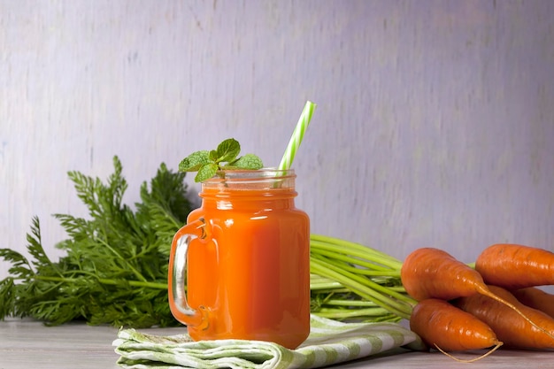 Delicioso y saludable jugo de zanahorias tiernas Jugo de zanahoria Zanahorias frescas con hojas verdes
