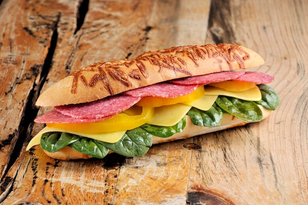 Foto delicioso sanduíche de baguete com salame e queijo