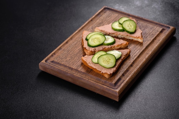 Delicioso sanduíche fresco com patê de fígado de frango com manteiga de torrada crocante e pepino