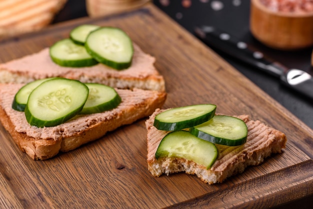 Delicioso sanduíche fresco com patê de fígado de frango com manteiga de torrada crocante e pepino