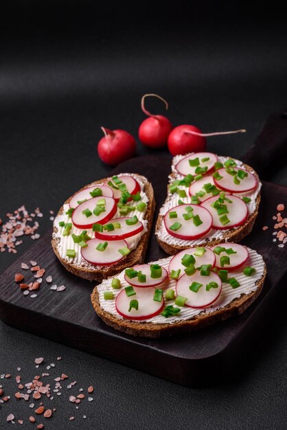 Delicioso sándwich o bruschetta con queso crema, rábano y cebolla verde