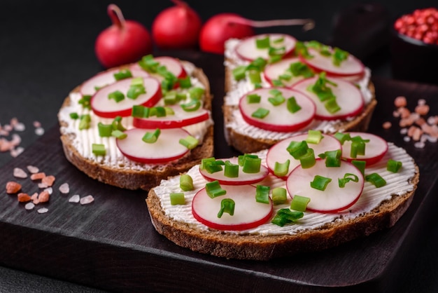 Delicioso sándwich o bruschetta con queso crema, rábano y cebolla verde