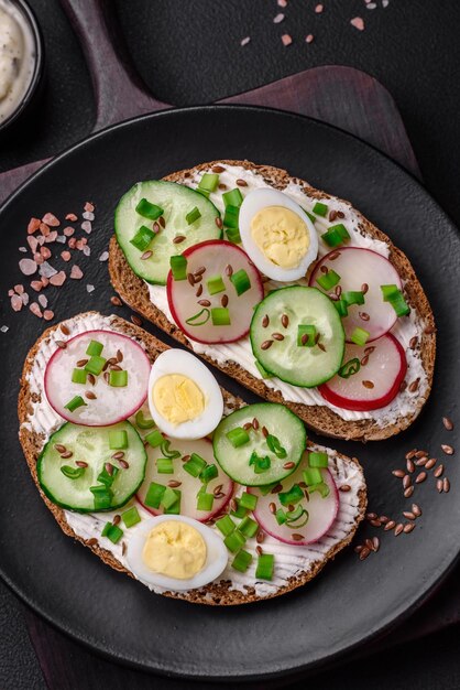 Delicioso sándwich o bruschetta con queso crema, rábano y cebolla verde