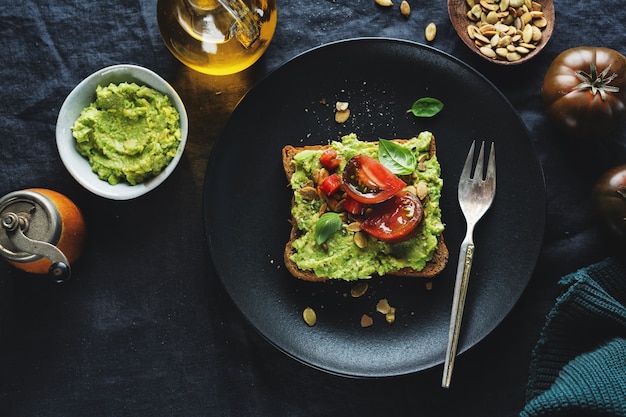 Delicioso sándwich de pan integral con puré de aguacate y tomates