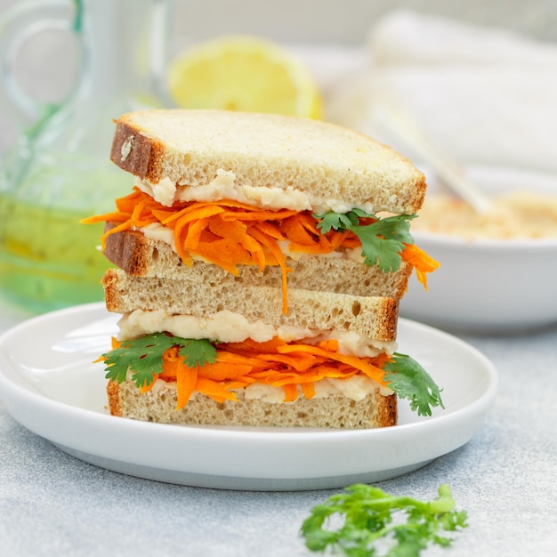 Delicioso sándwich picante de pan integral con zanahorias fritas hummus ajo y cilantro Desayuno saludable Cocina vegetariana Enfoque selectivo y espacio de copia