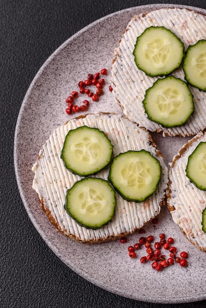 Delicioso sándwich vegetariano con tostadas a la parrilla, queso con crema, pepinos y semillas.