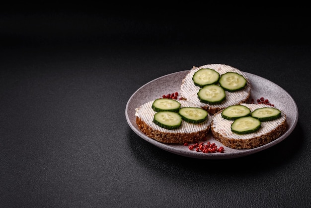 Delicioso sándwich vegetariano con tostadas a la parrilla, queso con crema, pepinos y semillas.