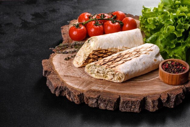 Delicioso shawarma fresco com carne e legumes em uma mesa de concreto escura
