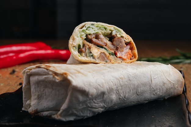 Delicioso shawarma suculento em uma superfície preta