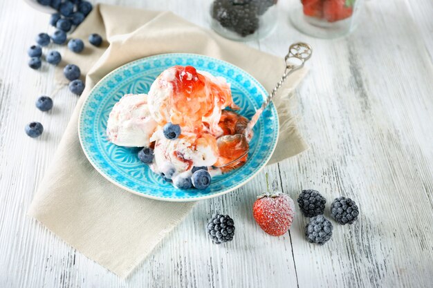 Delicioso sorvete com frutas frescas congeladas e molho, na cor de madeira