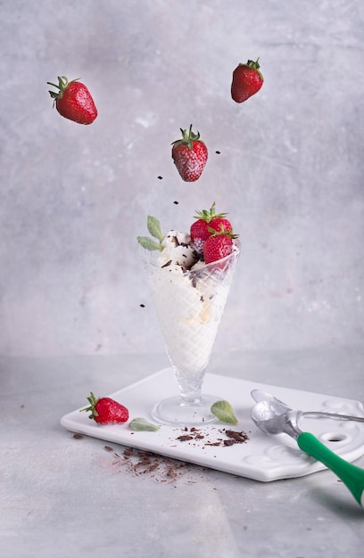 Delicioso sorvete de morango com hortelã em um fundo branco em uma mesa cinza