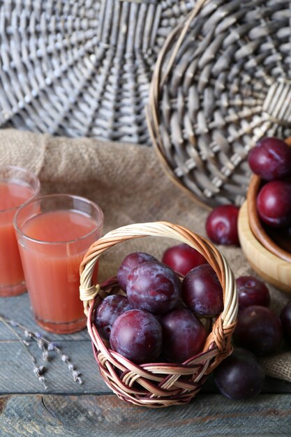 Delicioso suco de ameixa com frutas na superfície de vime