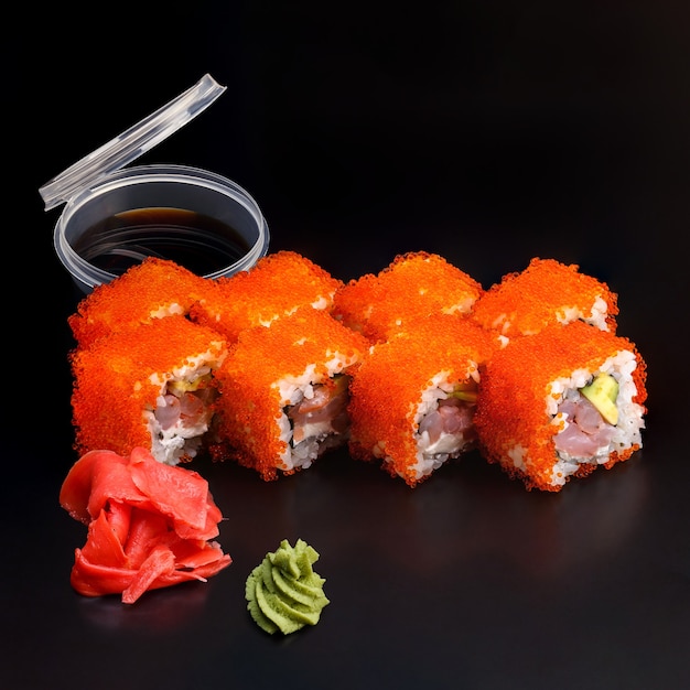 Delicioso sushi tradicional California King fresco em uma superfície preta