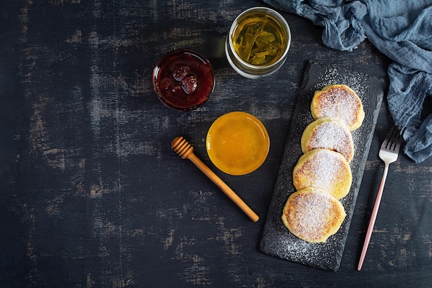 Delicioso syrniki casero con mermelada de fresa y miel Plato tradicional ruso syrniki Vista superior