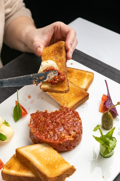 Foto delicioso tartar en un plato blanco con picatostes