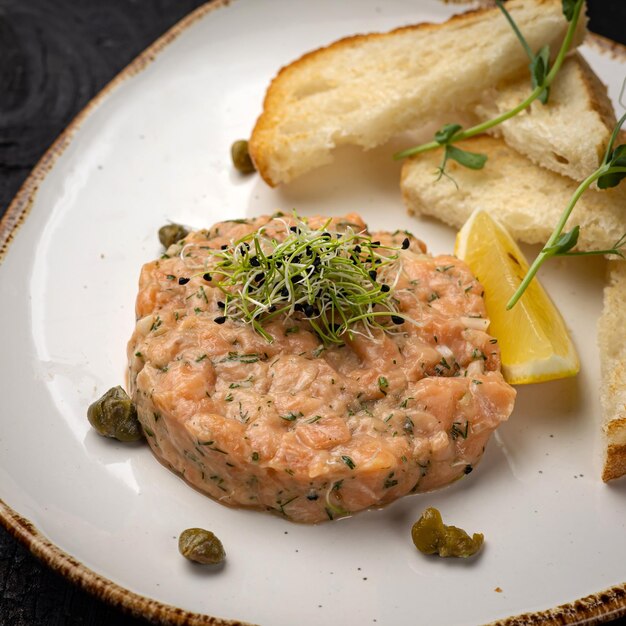 delicioso tartar de salmón con picatostes y limón